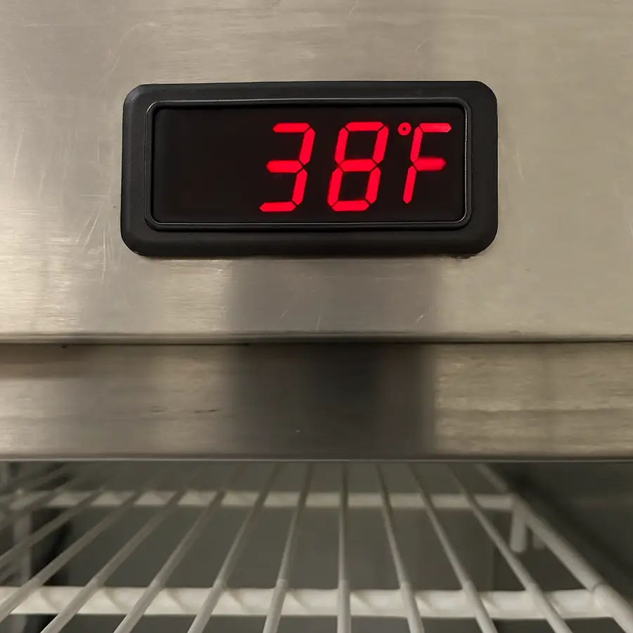A simple photo of a commercial refrigerator's digital thermometer reading exactly 38 degrees Fahrenheit.