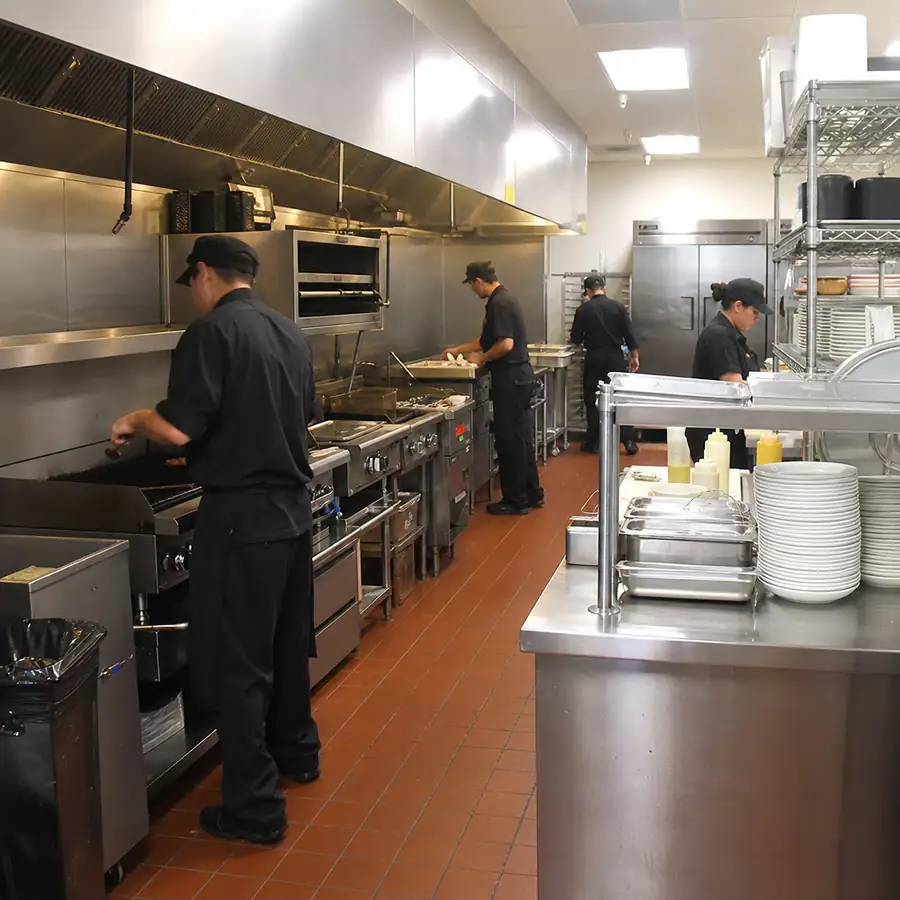 A bustling commercial kitchen featuring shining stainless steel restaurant equipment