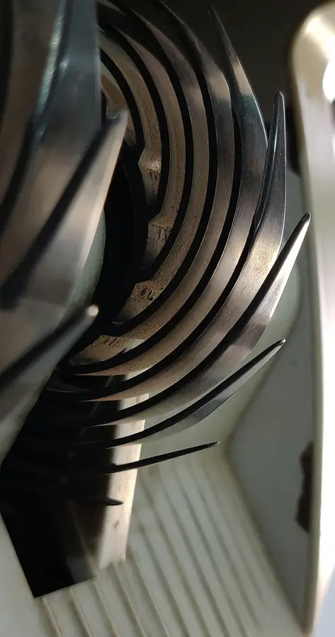 A meat slicer being cleaned with disassembled parts
