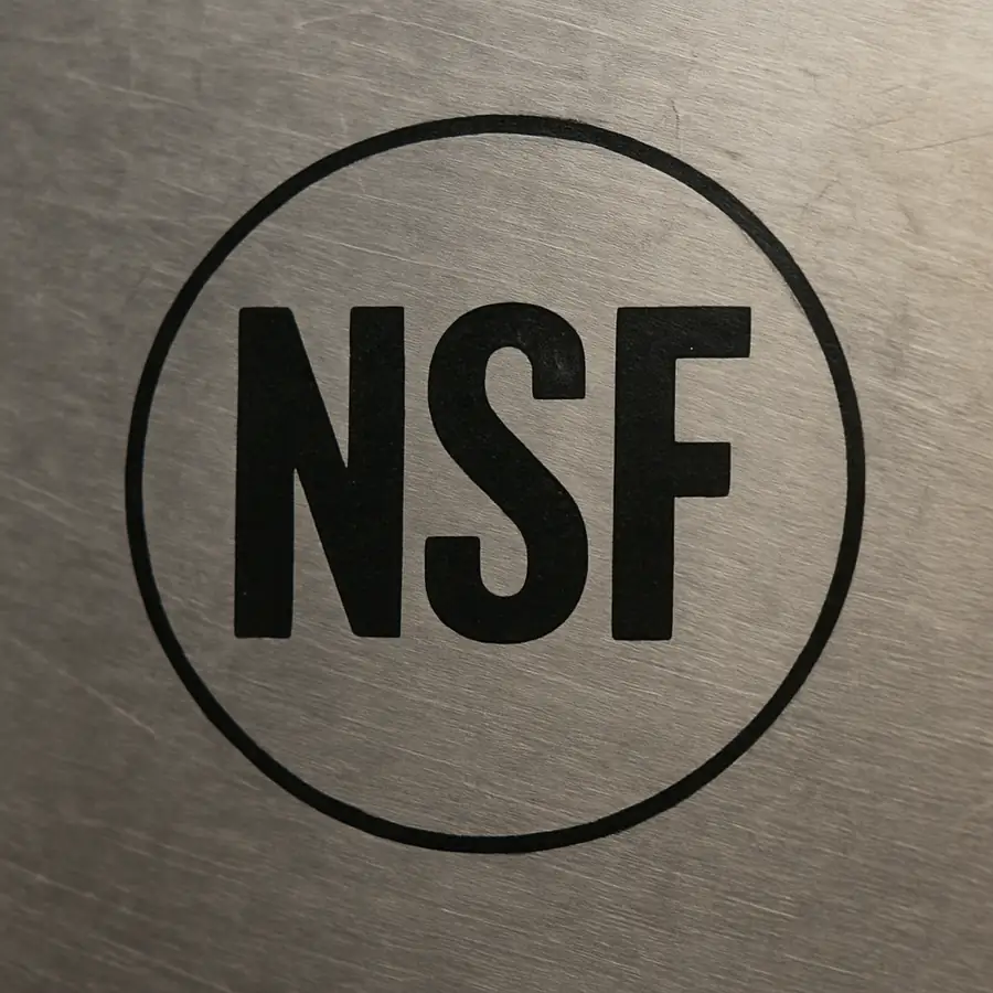 A close-up photo of an NSF certification mark on a stainless steel surface