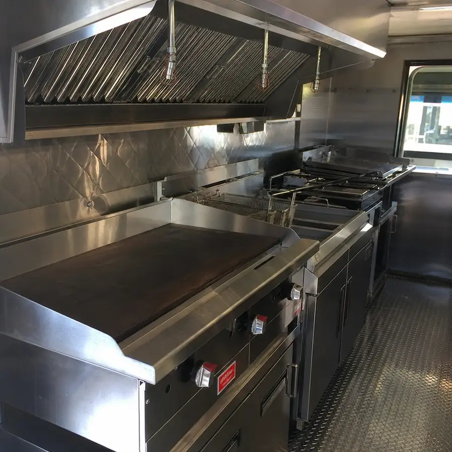 A detailed close-up of a high-quality stainless steel commercial kitchen inside a food truck