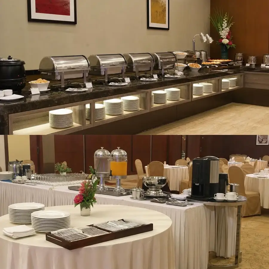 Hotel buffet and banquet setup with stainless chafing dishes, stacked plates, beverage dispensers, coffee station, and banquet tables