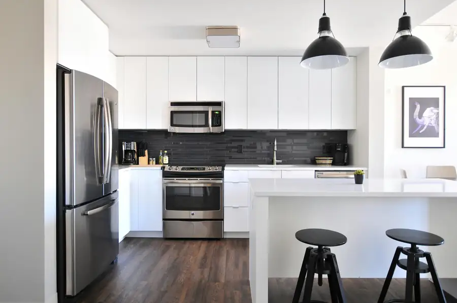 Modern kitchen appliances including refrigerator oven microwave and small appliances
