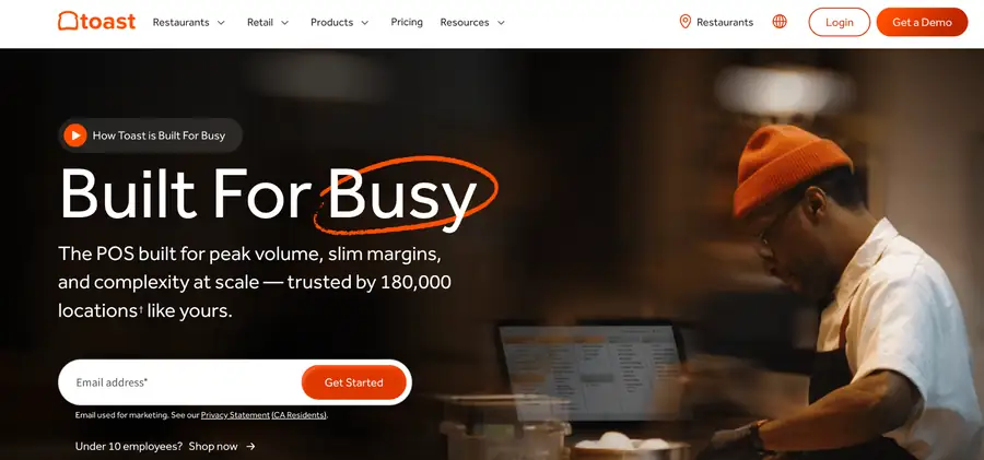 Toast POS homepage with Built For Busy headline and a chef using a kitchen display in a restaurant kitchen