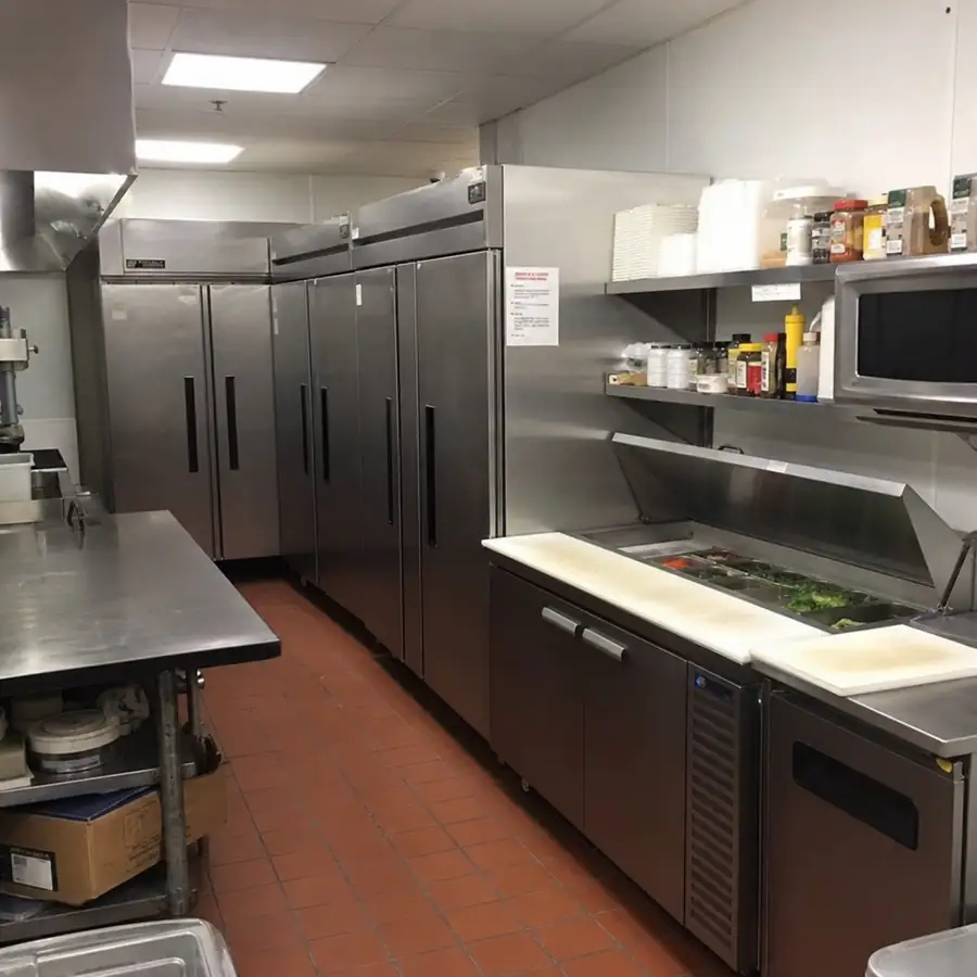 True commercial refrigeration lineup with stainless steel reach-in refrigerators and glass-door merchandisers in a professional kitchen