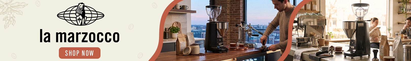 La Marzocco commercial espresso machines and coffee grinders in a professional café environment with barista preparing specialty coffee.